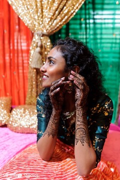 Indian bride touching her earrings with her henna decorated hands. Indian bride touching her earrings with her henna decorated hands.