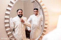 Indian groom and his bestman taking a look in the mirror. Indian groom and his bestman taking a look in the mirror.