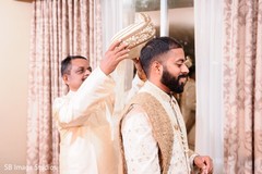 Indian groom being assisted with his groom. Indian groom being assisted with his groom.