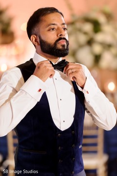 Indian groom tying his bow tie. Indian groom tying his bow tie.