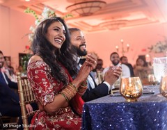 Maharani and Raja at their reception table smiling. Maharani and Raja at their reception table smiling.