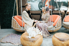 Indian couple sitting on hanging couches. Indian couple sitting on hanging couches.