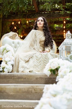 Indian bride surrounded by white floral decor arrangements. Indian bride surrounded by white floral decor arrangements.