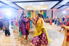 Indian couple dancing at Sangeet with dandiya sticks. Indian couple dancing at Sangeet with dandiya sticks.