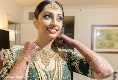 Indian bride putting on her ceremony choker necklace. Indian bride putting on her ceremony choker necklace.