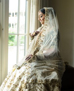 Indian bride wearing her white and golden ghoonghat veil. Indian bride wearing her white and golden ghoonghat veil.