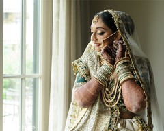 Indian bride putting her earrings on. Indian bride putting her earrings on.