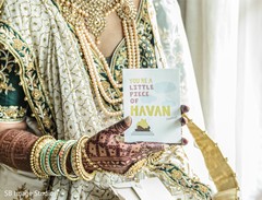 Maharani with her golden chooras holding a card . Maharani with her golden chooras holding a card .