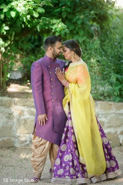 Indian couple with their purple and yellow sangeet outfits. Indian couple with their purple and yellow sangeet outfits.