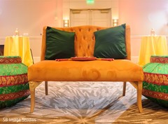 Orange sofa with dark green pillows for Sangeet couple's stage. Orange sofa with dark green pillows for Sangeet couple's stage.