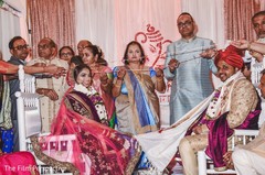 Indian bride and groom with their families during the ceremony. Indian bride and groom with their families during the ceremony.