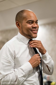 Indian groom putting on his black tie. Indian groom putting on his black tie.