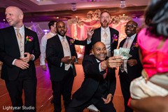 Indian groom paying for his shoes game. Indian groom paying for his shoes game.