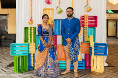 Indian couple in matching blue and gold with a decorated background Indian couple in matching blue and gold with a decorated background