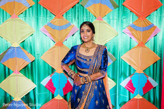 Maharani in blue and gold posing in front of the stage decoration Maharani in blue and gold posing in front of the stage decoration