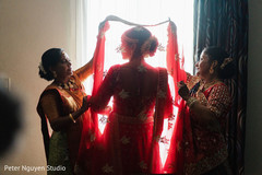 Indian relatives putting a red and gold veil on the Indian bride Indian relatives putting a red and gold veil on the Indian bride