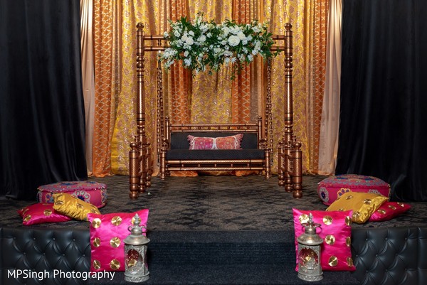 Indian pre-wedding golden and copper color stage decor.