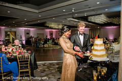 Indian bride and groom cutting white golden cake. Indian bride and groom cutting white golden cake.