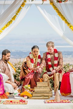 Indian couple pouring offerings on to sacred fire. Indian couple pouring offerings on to sacred fire.