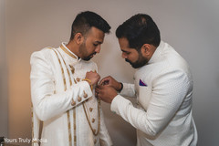 Indian relative helping Indian groom with his jewelry Indian relative helping Indian groom with his jewelry