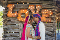 Indian couple holding each other close in front of a cabin Indian couple holding each other close in front of a cabin
