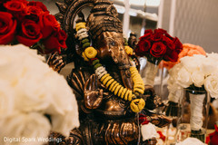 A statue of Ganesha on a table decorated with flowers A statue of Ganesha on a table decorated with flowers