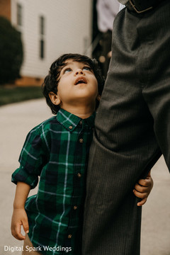 An Indian boy holding onto an adult's leg An Indian boy holding onto an adult's leg