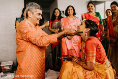 Senior male Indian relative applying tumeric paste to Maharani Senior male Indian relative applying tumeric paste to Maharani