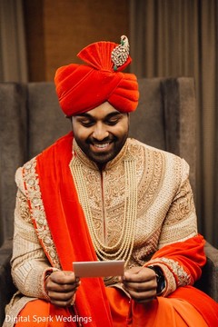 Indian groom smiling while reading the note he received Indian groom smiling while reading the note he received
