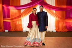 Indian bride and groom on their sangeet red, golden and blue outfits. Indian bride and groom on their sangeet red, golden and blue outfits.