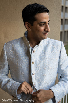 Indian groom putting his white embroidered sherwani. Indian groom putting his white embroidered sherwani.