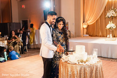 Indian bride and groom slicing their wedding cake. Indian bride and groom slicing their wedding cake.