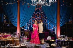 Indian groom standing with his Maharani in a decorated hall Indian groom standing with his Maharani in a decorated hall