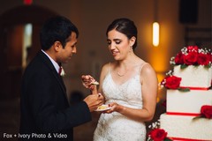 Indian bride and groom sharing a slice of cake during the reception. Indian bride and groom sharing a slice of cake during the reception.