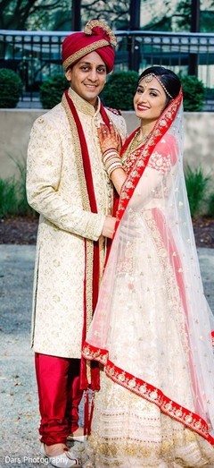Indian couple in matching beige and gold wedding outfits. Indian couple in matching beige and gold wedding outfits.
