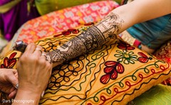 Indian mehndi artist making dark henna art on maharani's hands. Indian mehndi artist making dark henna art on maharani's hands.