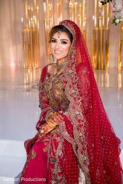 Maharani in red and gold posing on stage Maharani in red and gold posing on stage