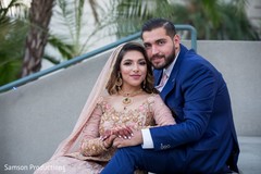 Indian newlyweds holding each other close while sitting on some steps Indian newlyweds holding each other close while sitting on some steps