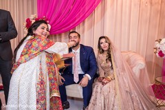 Indian relative feeding some sweets to the Indian groom Indian relative feeding some sweets to the Indian groom