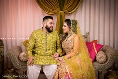 Indian couple staring at each other while sitting on stage Indian couple staring at each other while sitting on stage