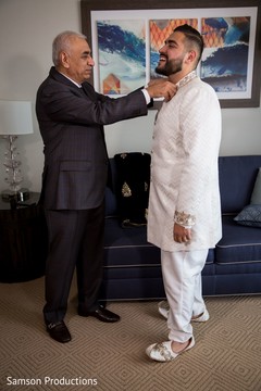 Indian relative helping the Indian groom to button his Kurta Indian relative helping the Indian groom to button his Kurta