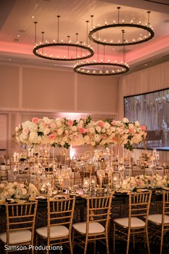 A table decorated with several tall flower arrangements A table decorated with several tall flower arrangements