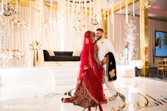 Indian newlyweds smiling together in front of the reception stage Indian newlyweds smiling together in front of the reception stage