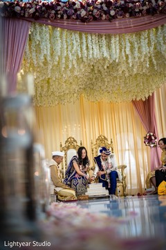 Indian couple getting married under a floral mandap. Indian couple getting married under a floral mandap.