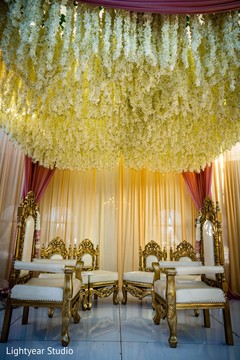 White flowers hanging from the mandap ceiling. White flowers hanging from the mandap ceiling.