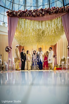 Indian bride and groom under a big floral mandap. Indian bride and groom under a big floral mandap.