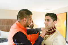 Indian relative helping the Indian groom with his Sherwani Indian relative helping the Indian groom with his Sherwani