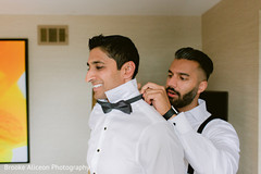 Indian groom being assisted with his bow tie. Indian groom being assisted with his bow tie.