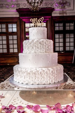 Indian white wedding cake with golden cake topper. Indian white wedding cake with golden cake topper.
