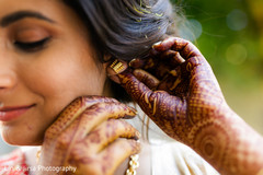 A close up to the Indian bride adjusting her earrings A close up to the Indian bride adjusting her earrings